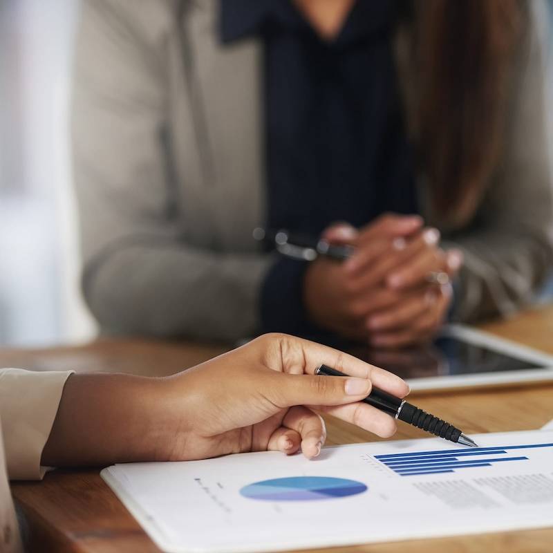 A business woman is writing on a piece of paper.